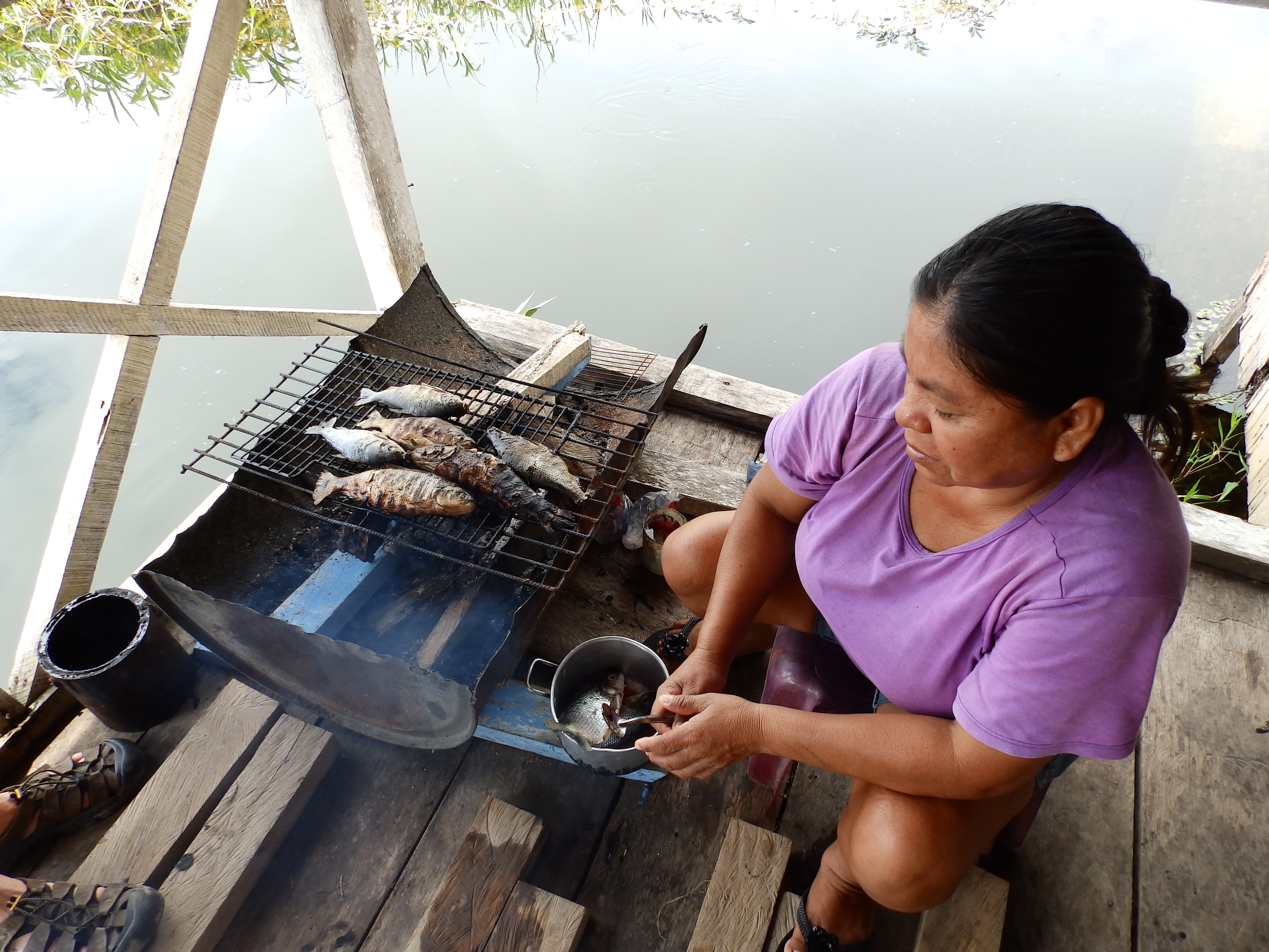 Mujer indígena ahumando pescado
